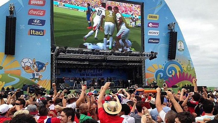 игроки в футбол на стадионе и на экране одновременно