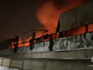 Пожарным удалось остановить распространение огня в горящем цеху в Рузе