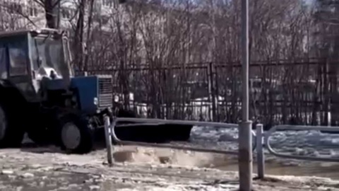 В Озерске трактор ковшом разгоняет лужу